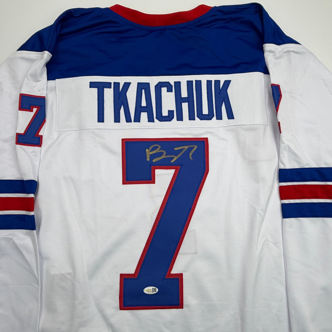 Autographed/Signed Brady Tkachuk USA 2026 Olympics Gold White Jersey JSA COA