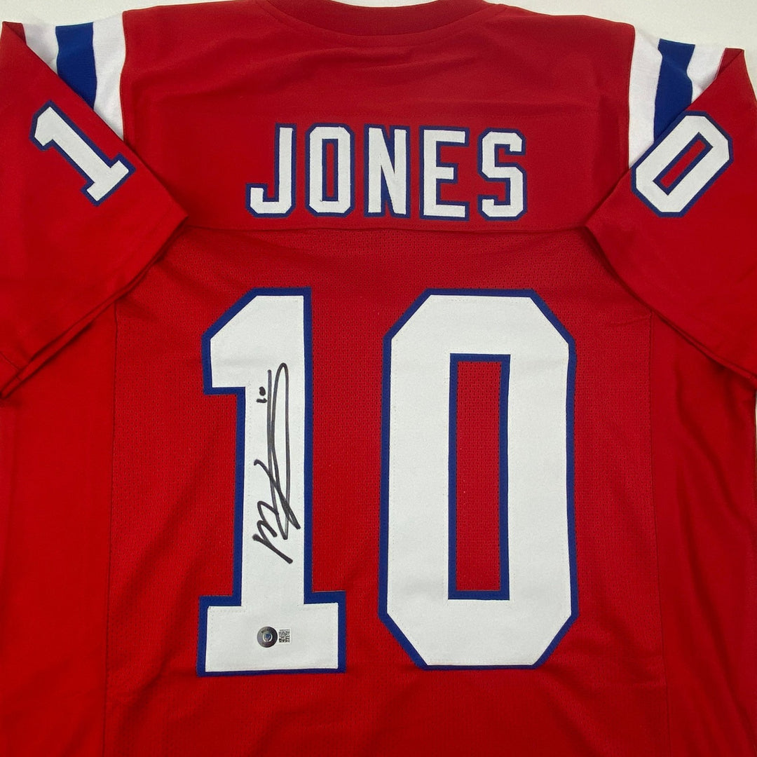Autographed/Signed Mac Jones New England Red Jersey Beckett BAS COA