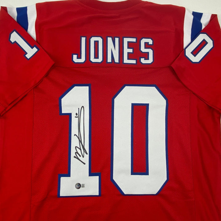 Autographed/Signed Mac Jones New England Red Jersey Beckett BAS COA