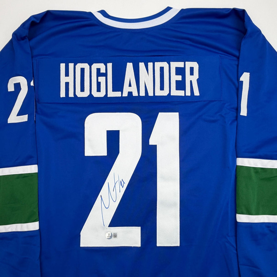 Autographed/Signed Nils Hoglander Vancouver Blue Hockey Jersey Beckett COA