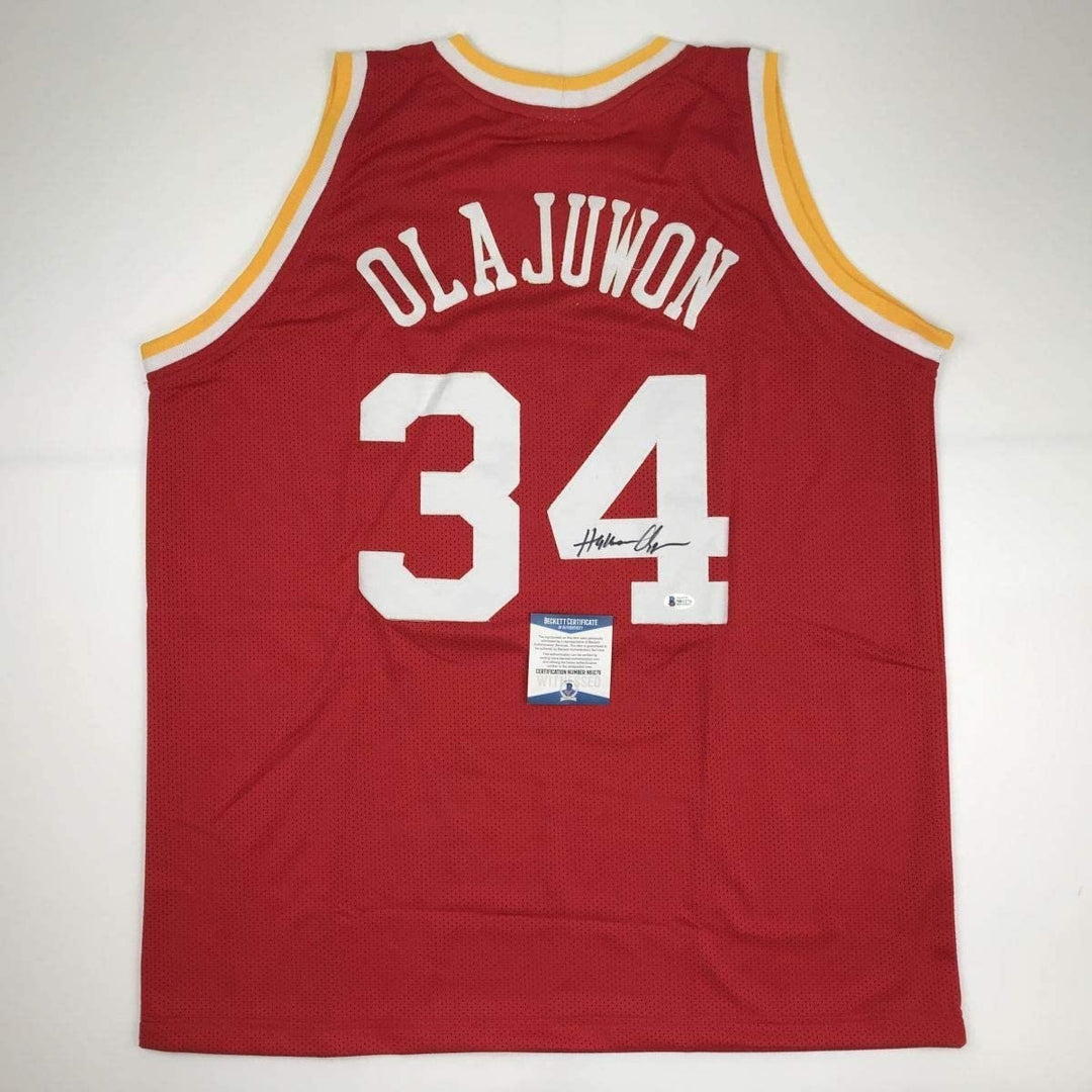 Autographed/Signed Hakeem Olajuwon Houston Red Jersey Beckett COA