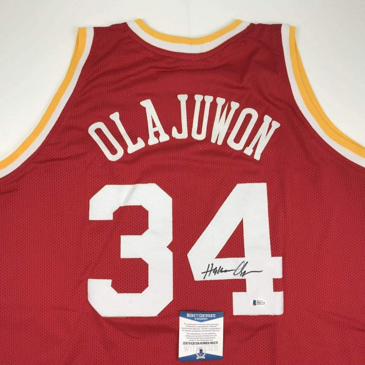 Autographed/Signed Hakeem Olajuwon Houston Red Jersey Beckett COA
